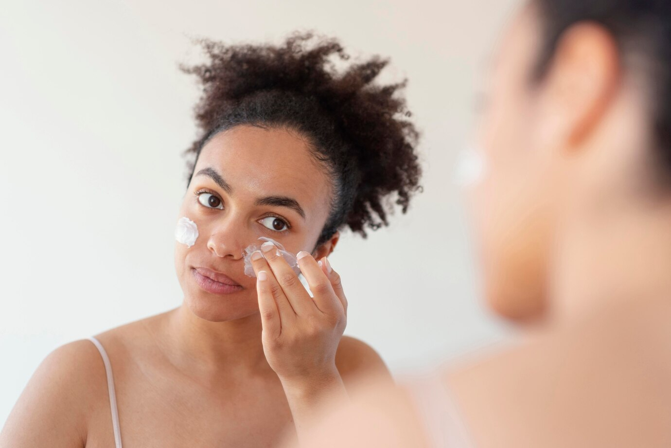 Mulher negra fazendo limpeza de pele.