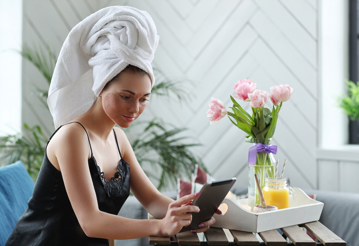 Mulher sentada fazendo tratamento facial segurando um tablet